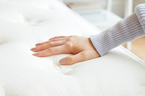 Hand pressing on mattress