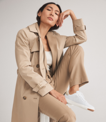 Woman sitting on a stool wearing sneakers