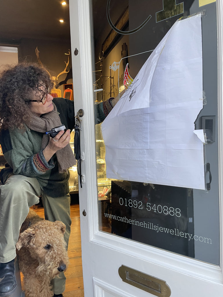 Catherine Hills and Rolo lettering the shop door