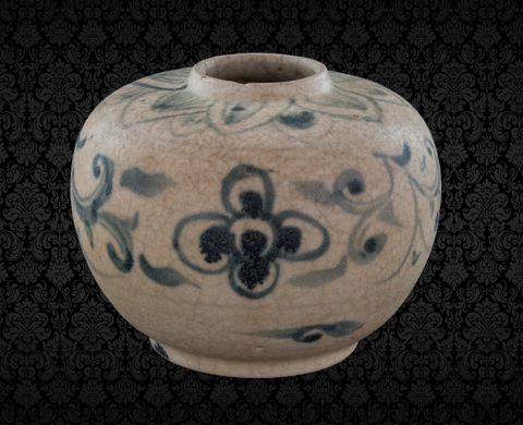 Vietnamese porcelain jar from the 20th – 21st Buddhist centuries, displayed in the Chumphon National Museum. It features a smooth, unglazed white clay texture, with a narrow, elevated rim. The jar is decorated with intricate lotus patterns on the shoulder and floral designs on its bloated body, standing on a pedestal base