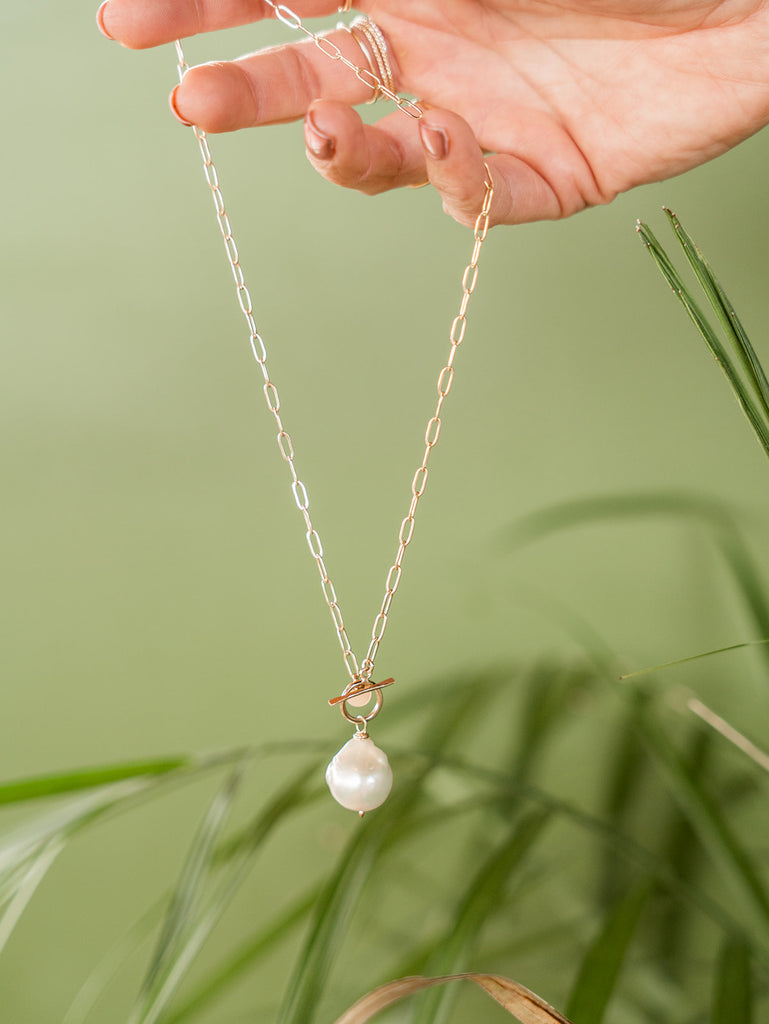 Baroque pearl hangs from a gold paper clip chain with togggle clasp