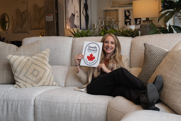 Blonde girl with a Family-Owned sign at Perfect Home Furniture