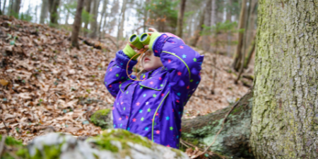 kid with binoculars in forest