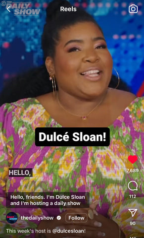 A screenshot of Dulce Sloan hosting The Daily Show wearing the gemstone necklace and earrings in gold/spinel