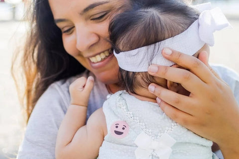 Buzz Patch Mosquito repellent sticker on baby being held by mum