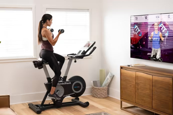 woman doing dumbbell workout on Studio Bike 1000