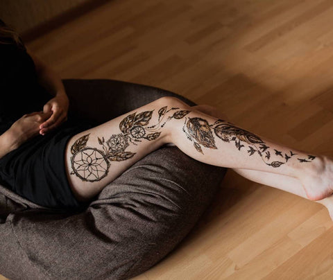 Grand Tatouage Attrape-rêve sur jambe avec plume et hirondelles
