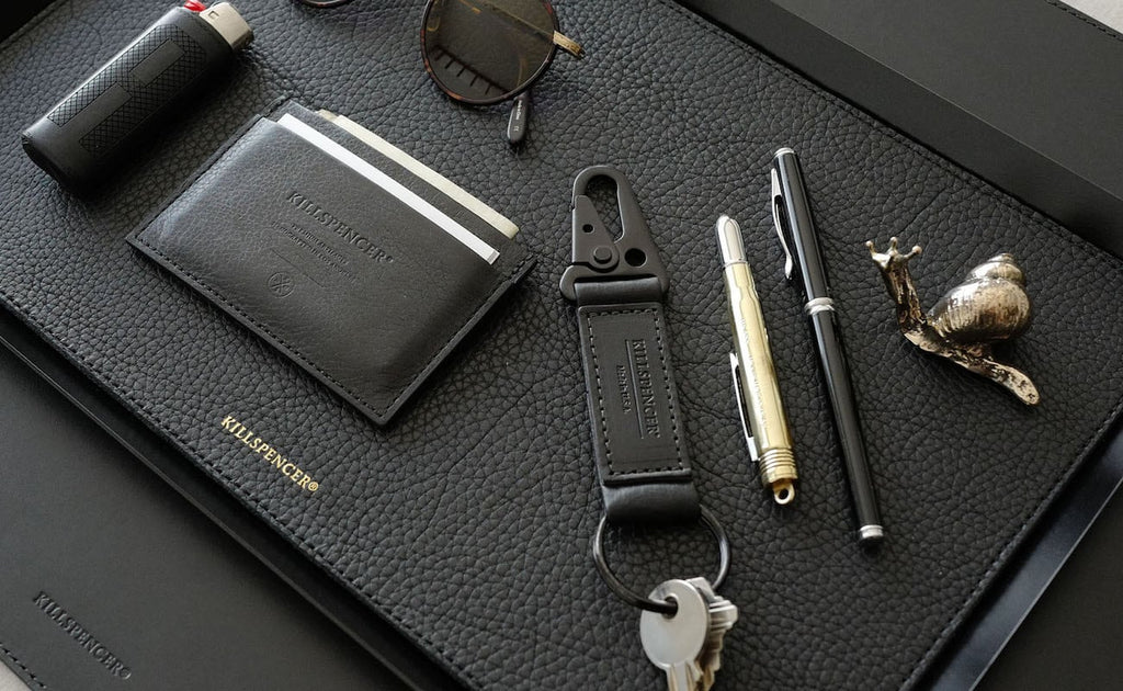 black leather valet tray displaying personal items