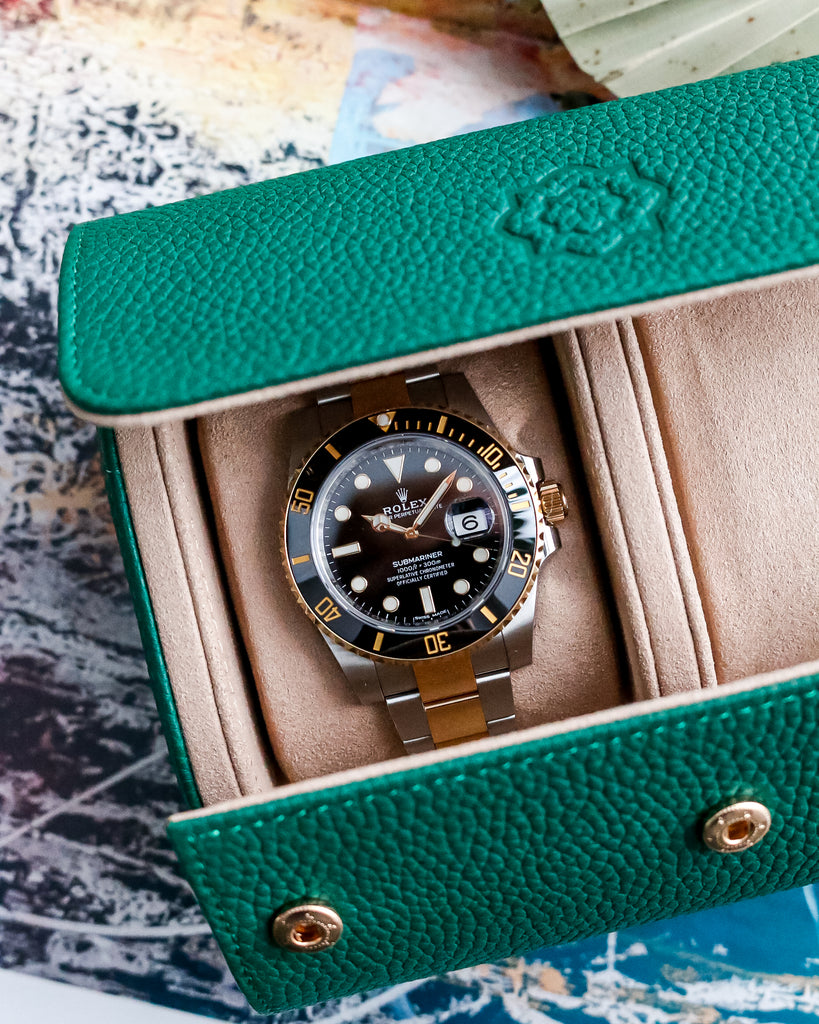 rolex submariner 116613ln sitting in a vallae goods luxury leather emerald green duplo watch roll