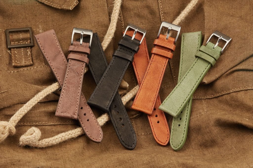 four high quality leather watch straps sitting on leather background