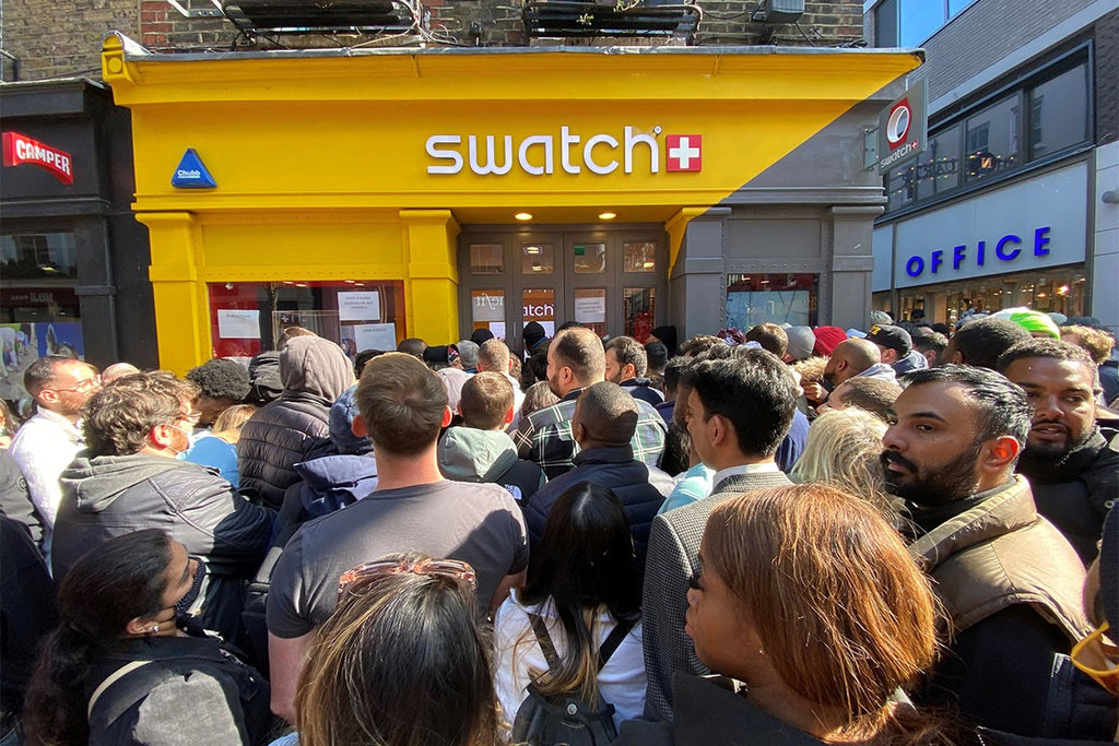 gathering of people in front of swatch watch store