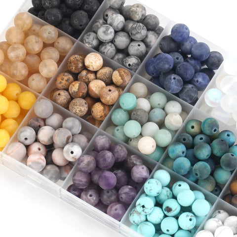 Eine Auswahl lebendiger Perlen liegt auf einem Basteltisch ausgebreitet