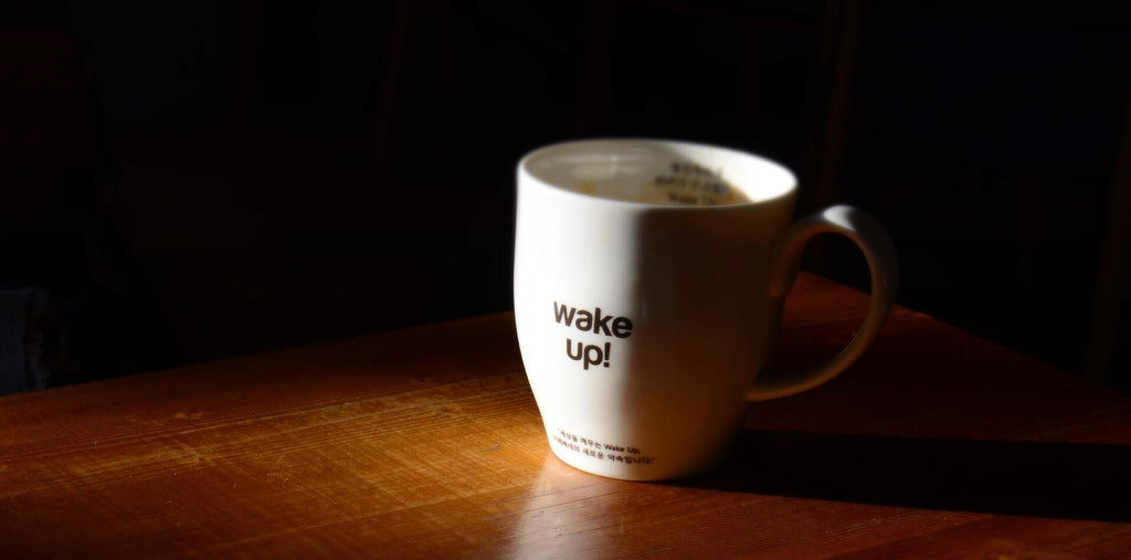 A cup of coffee with the phrase "wake up"