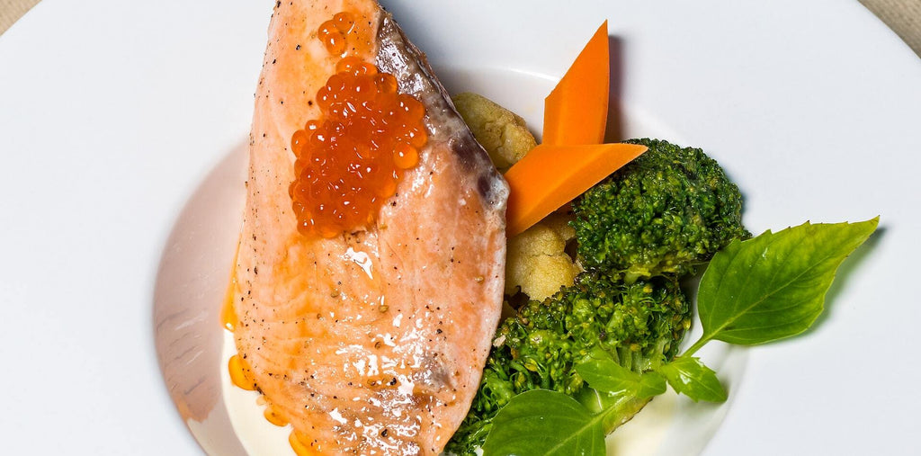 Salmon, goldfish meal with caviar, vegetables close up