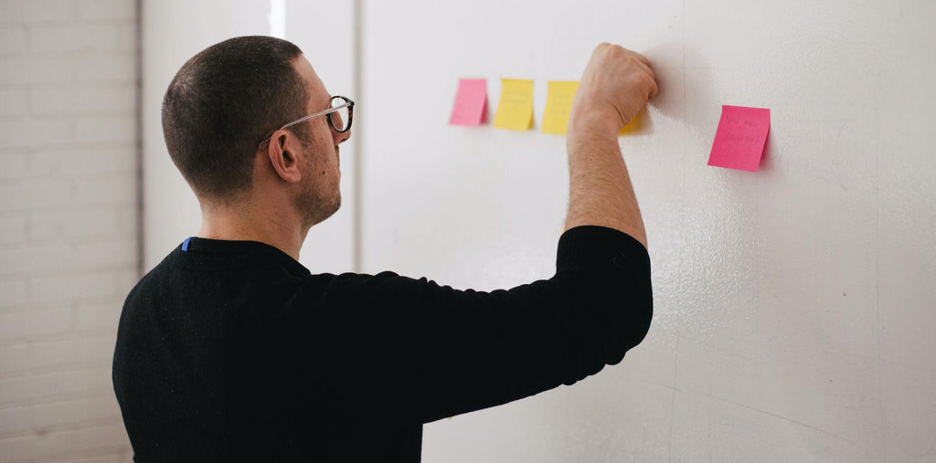 A man is checking stickers on the wall