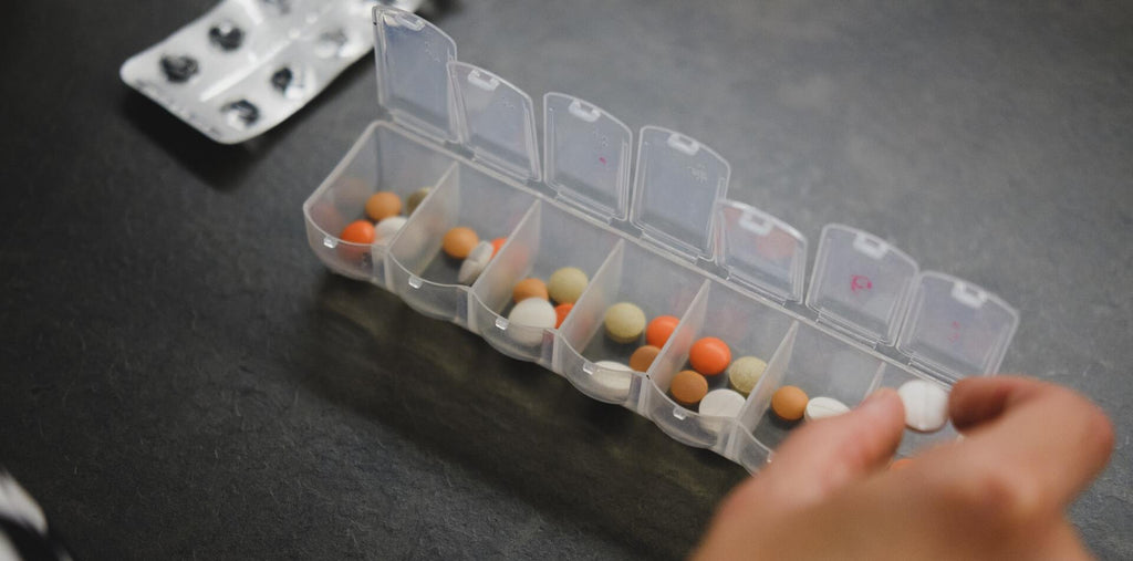Person taking supplements from the pill box