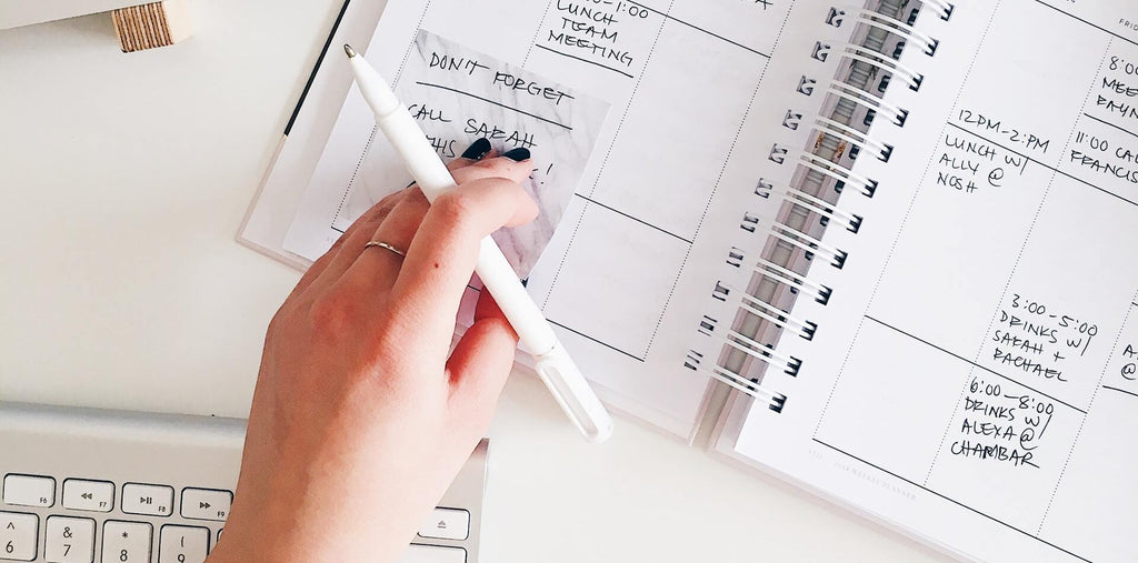 person holding notepad and pen