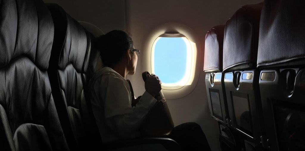 A man looking in the window while flying on the plane