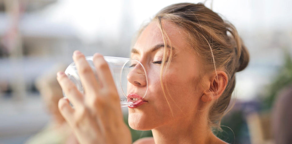 woman drinks a cup of water