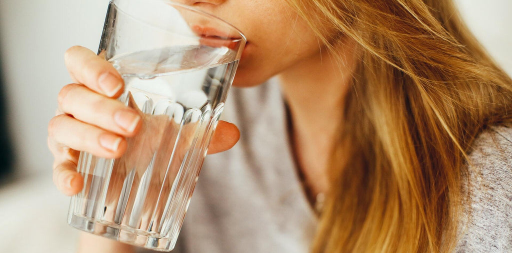 woman drinking water to stay hydrated and energized