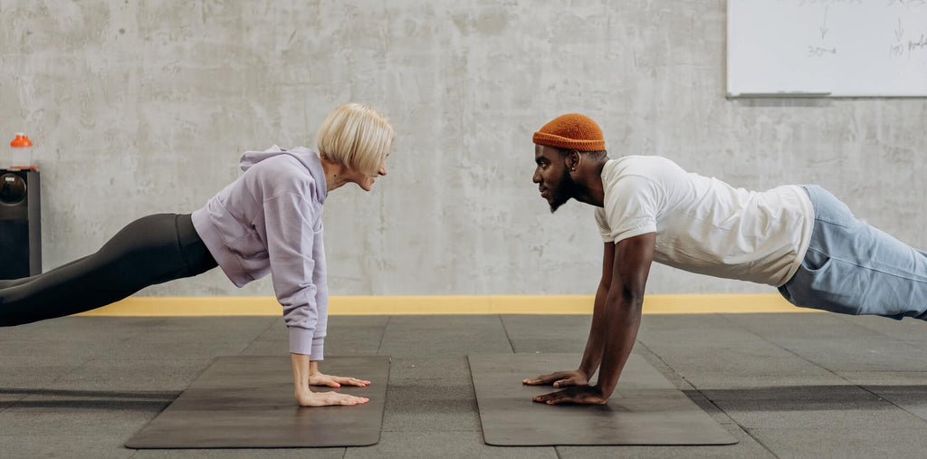 Man and woman standing in a plank next to each other