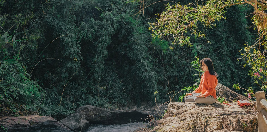 Woman meditating near the river