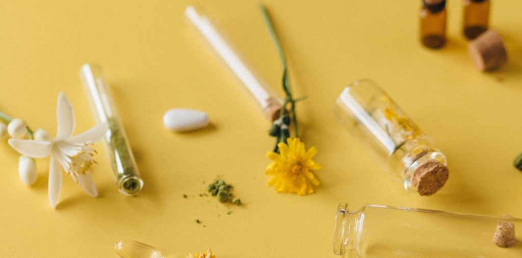 Pills and flowers on yellow background