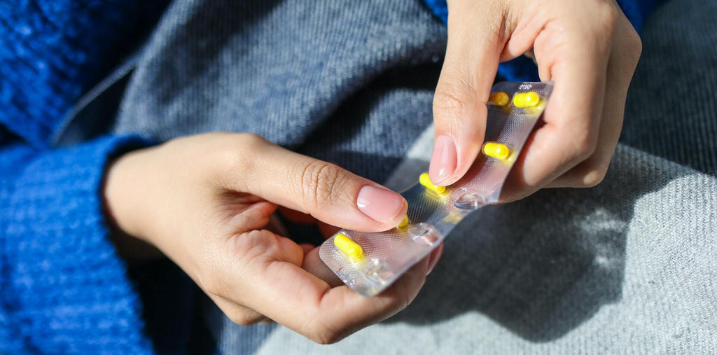 A woman taking zinc supplements from a blister