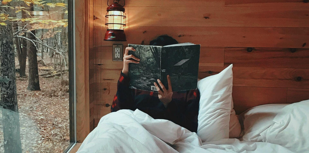 A person reading the book laying in a bed