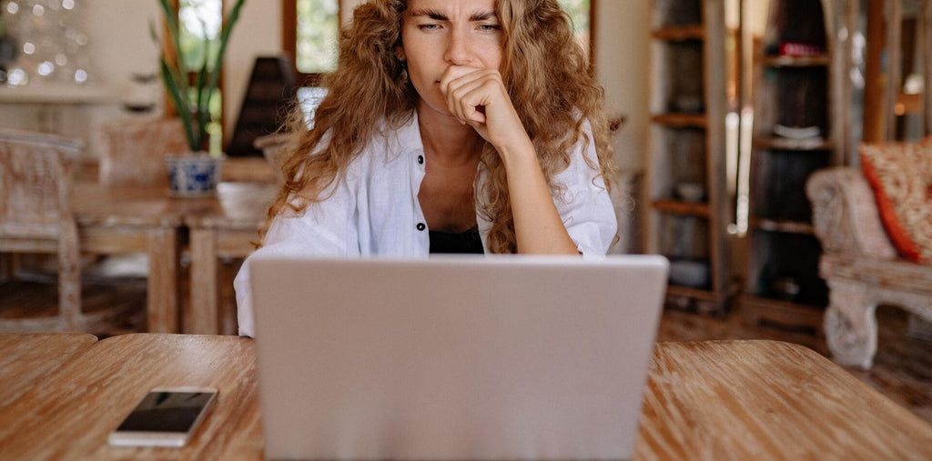 woman looking serious while using laptop
