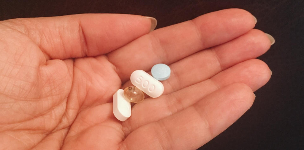 A few supplement pills on a palm
