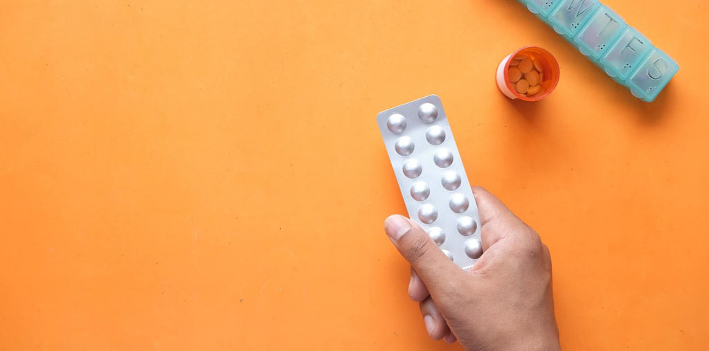 Tablets in the hand on an orange background