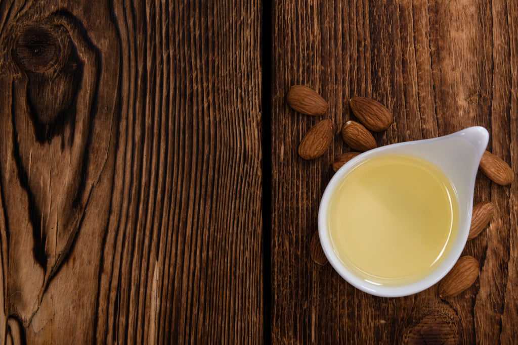 Sweet Almond Oil in a ceramic container placed on a wooden table 