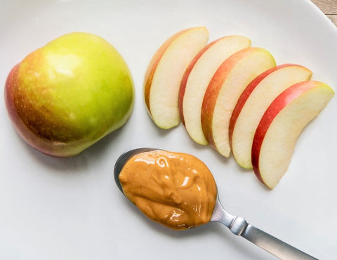 Grouped photo of a tablespoon full of peanut butter, a whole apple, and sliced apples