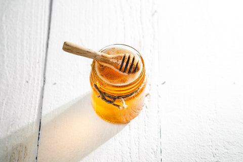 honey in a glass jar on a wooden table