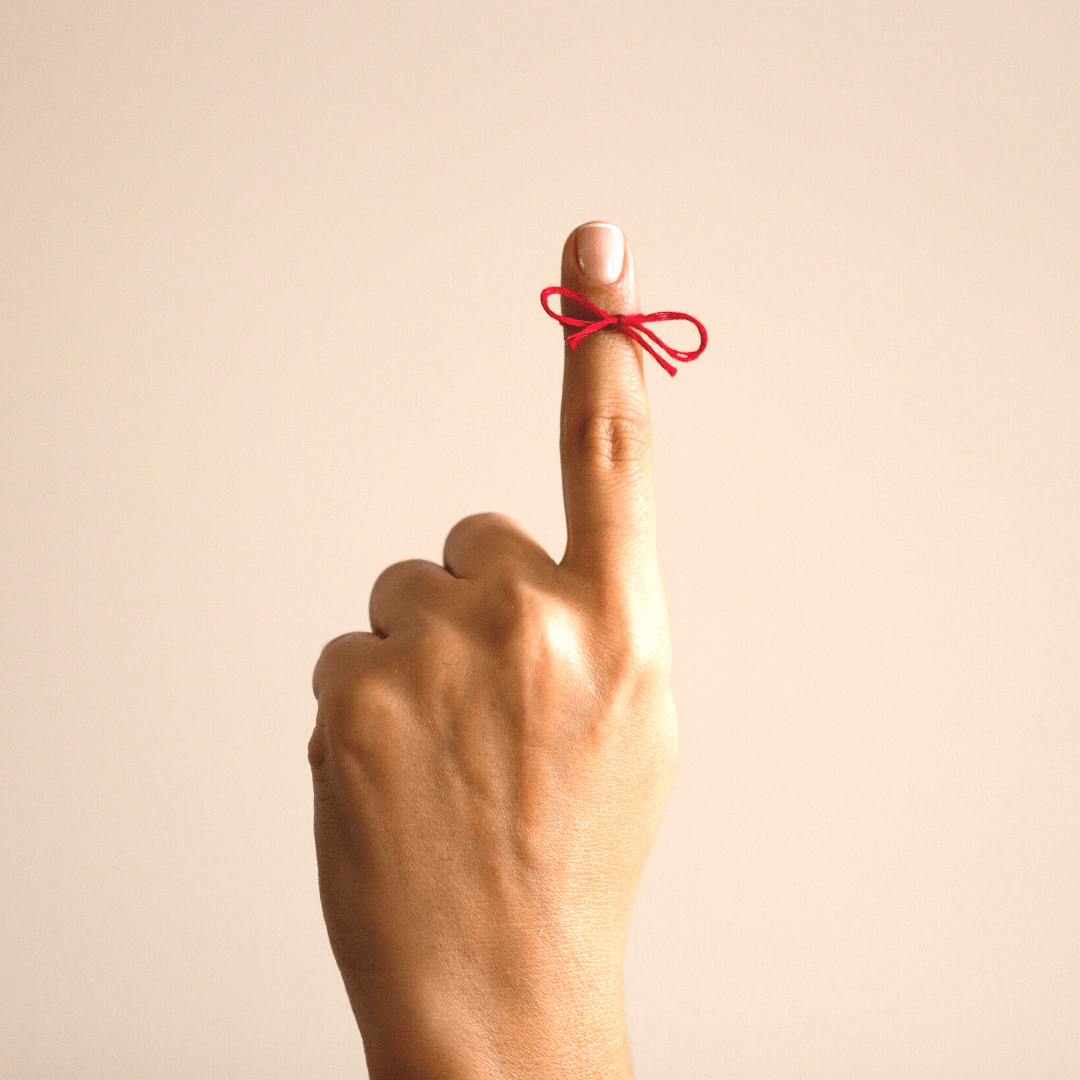 Finger with a bow tied to it 
