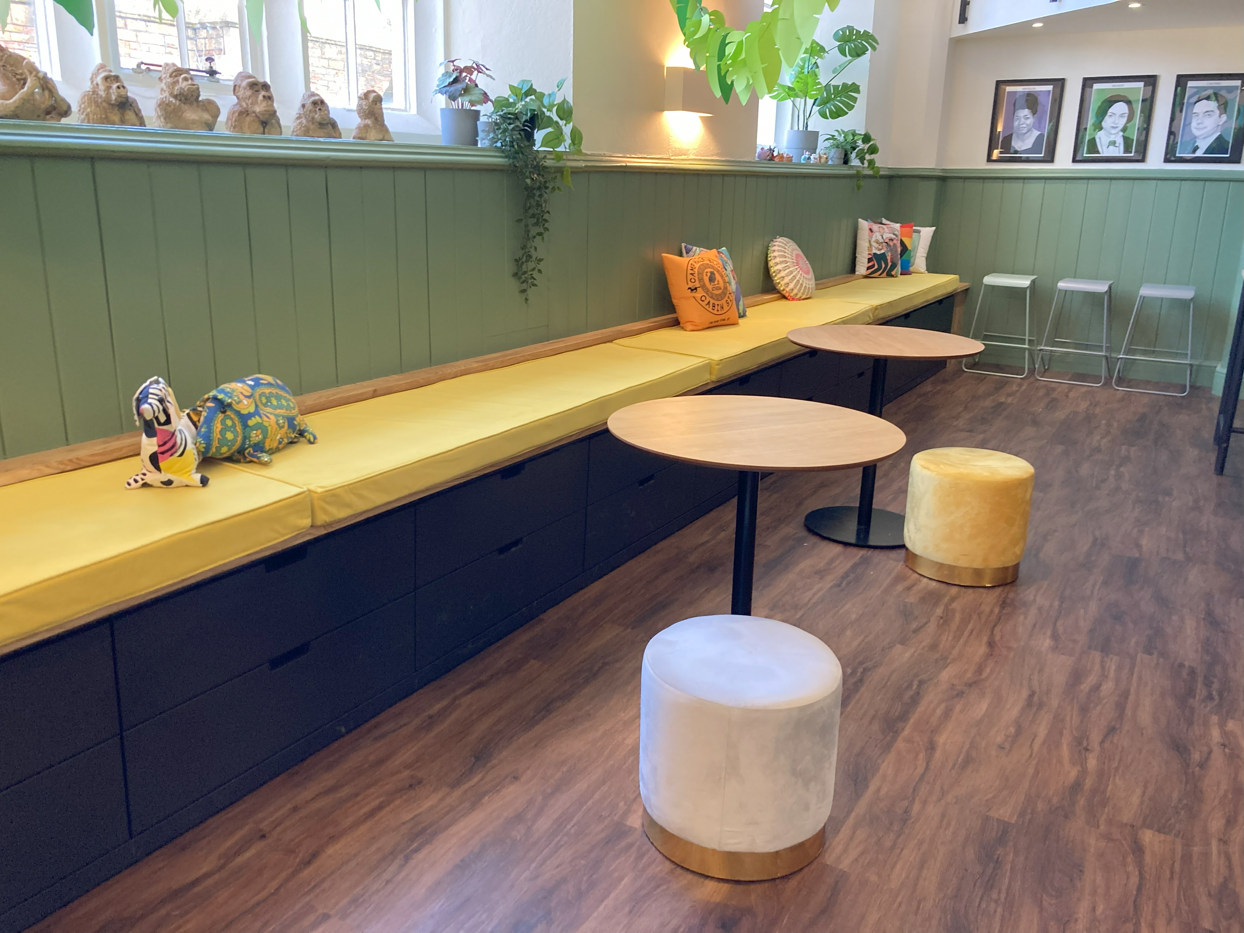 A college social room with one long bench along one side of the room. It's topped with a jolly set of bright yellow velvet bench cushions, with piping in a 10cm thick foam.