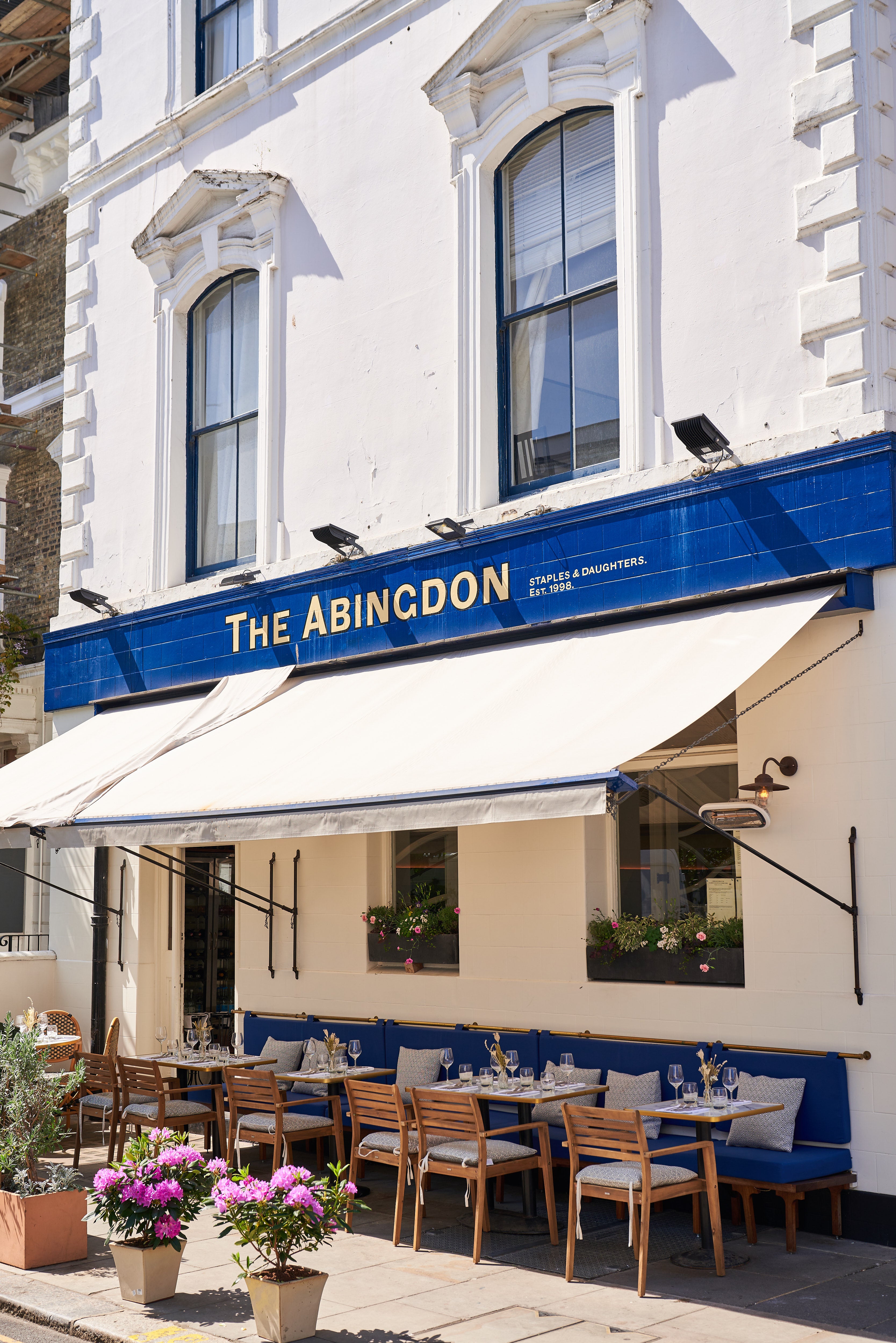 The front of a London restaurant called the Abingdon with a seating area in mid blue fabric