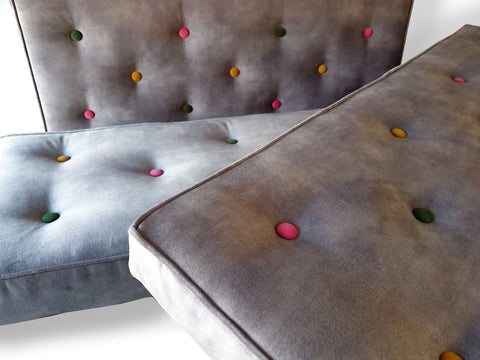 A piped bench cushion for a kitchen dining bench in a soft grey hardwearing velvet fabric by Warwick with colour pop buttons in pink green and yellow velvet