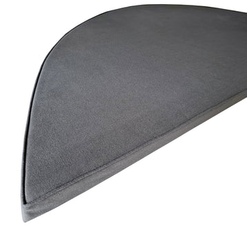 A window seat cushion with a curved back for a bay window seat. The bench seat cushion has a mid grey, hardwearing fabric cover that has a zip at the back so the cover can be cleaned. The cover has piped edges. The cushion is bespoke made to order and a perfect fit.