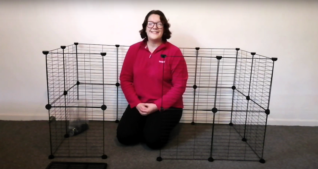 Woman showing how to assemble a Kavee C&C cage for rabbits