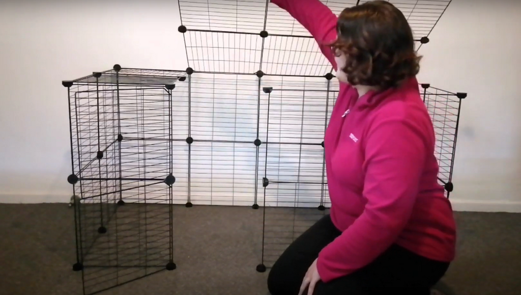 Woman showing how to set up a Kavee C&C rabbit cage