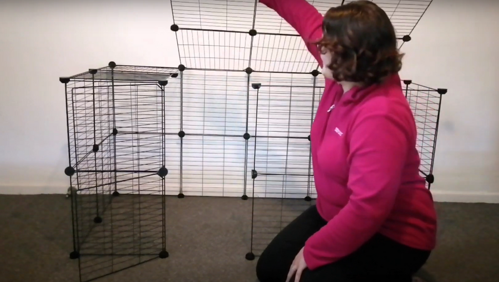 Woman opening the lid of an assembled Kavee C&C cage for rabbits
