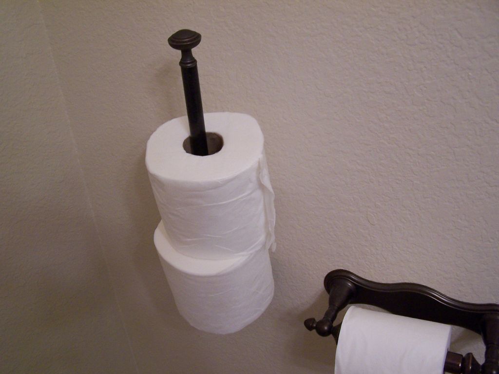 toilet paper with two extra rolls to the side