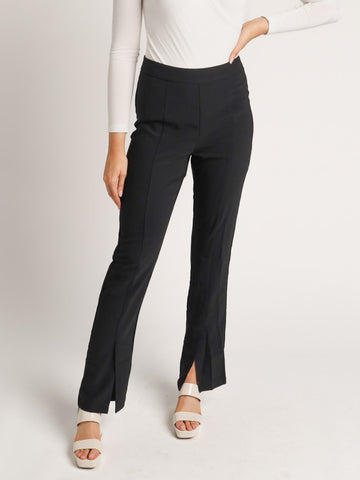 Model wearing black trousers with slits in hemline.