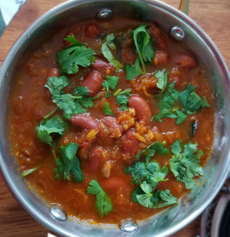 Copper pot filled with rajma and a sprinkle of fresh cilantro leaves