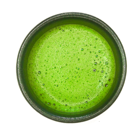 black cup filled with bright green matcha tea