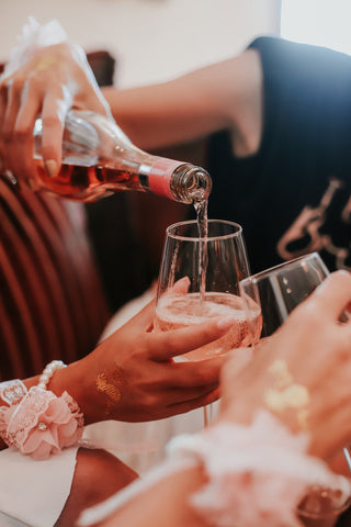 hand pouring rose wine