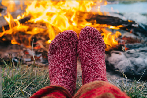 Woman's feet wearing red wool socks by fire