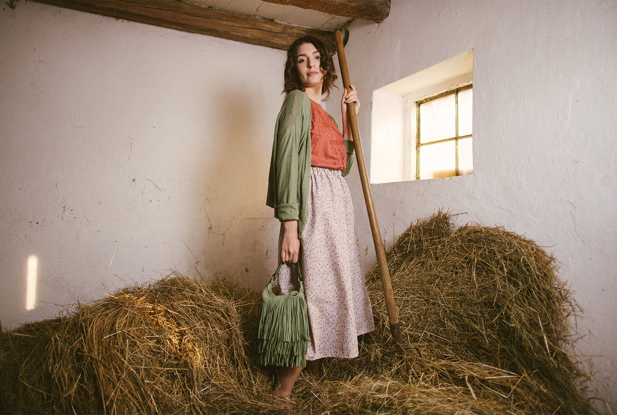 Donna con in mano una borsa verde in pelle 100% italiana marchiata 